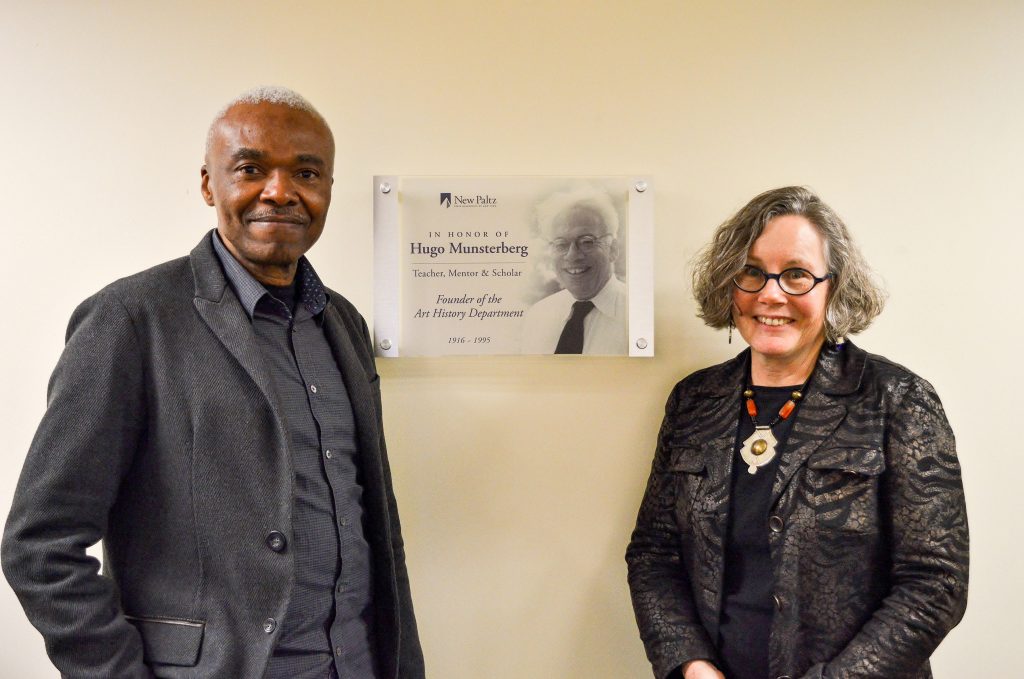 Speakers for the AHA 2017 Symposium, Studies in African Art, pose with the plaque honoring the founder of the Art History department, Dr. Hugo Munsterberg, installed in the Art History Visual Resources Study Room, SAB 106C. Photo by Katie Gantley