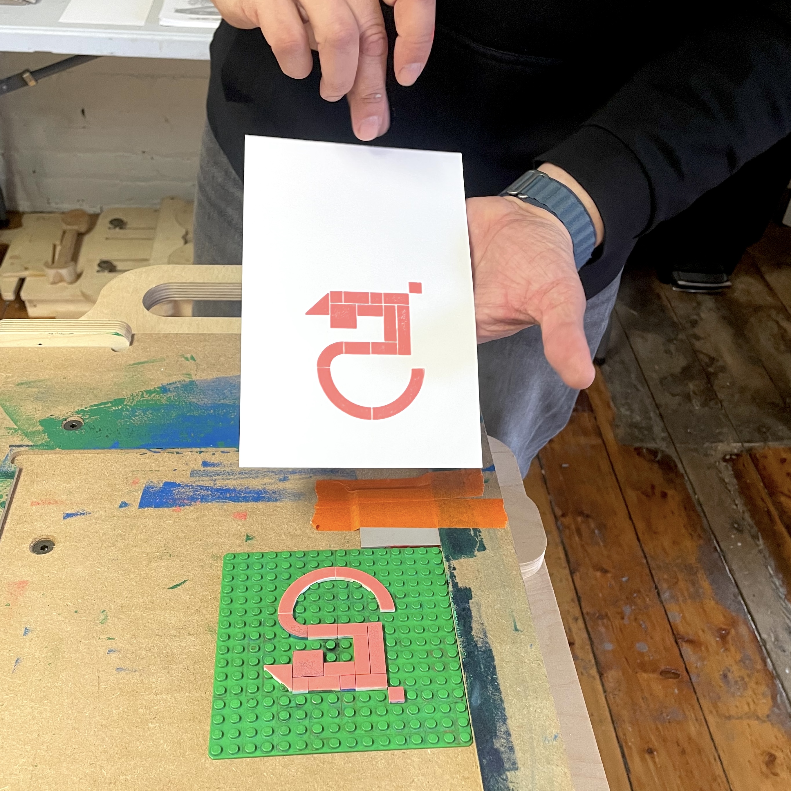 a person holding a print of the number 5 from a lego set